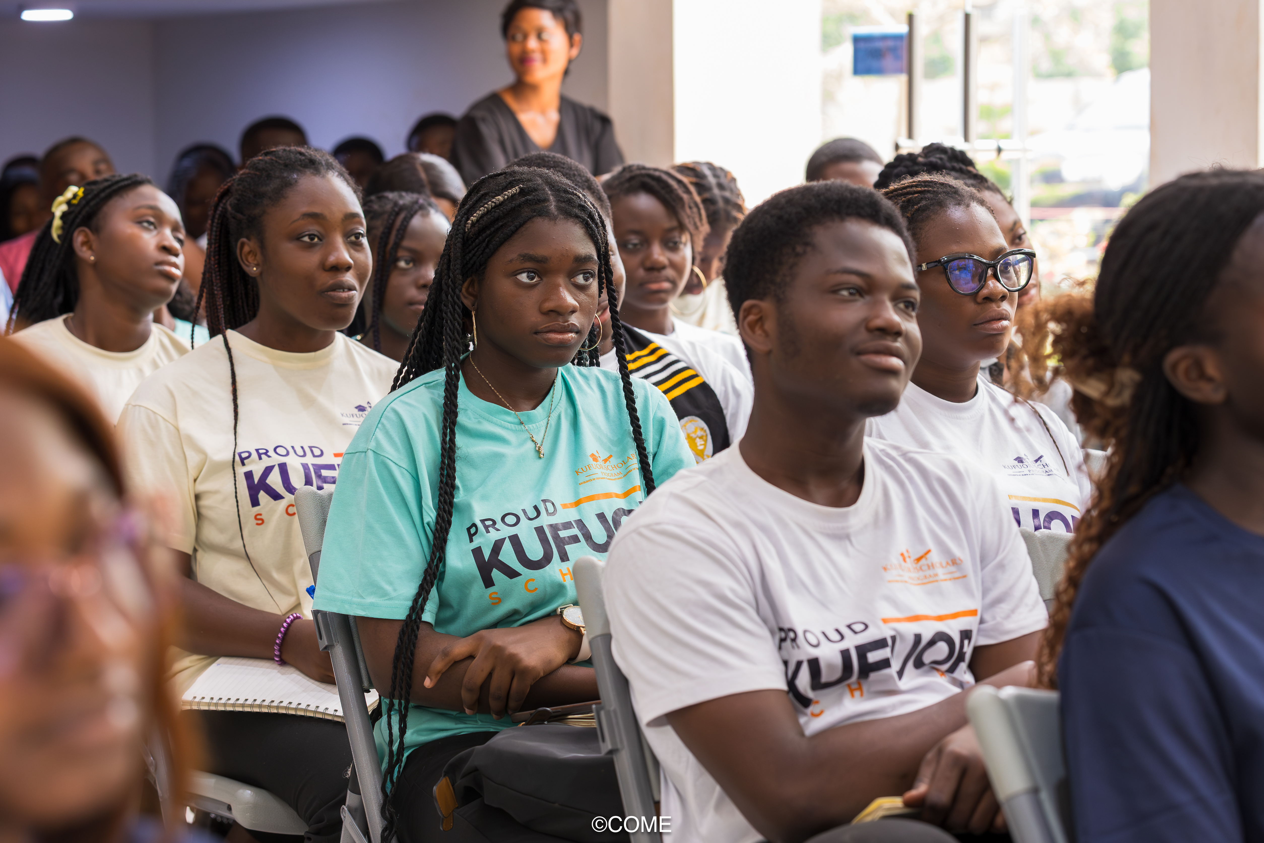 Kufuor Scholars seated indoors, attentively following a seminar or presentation.